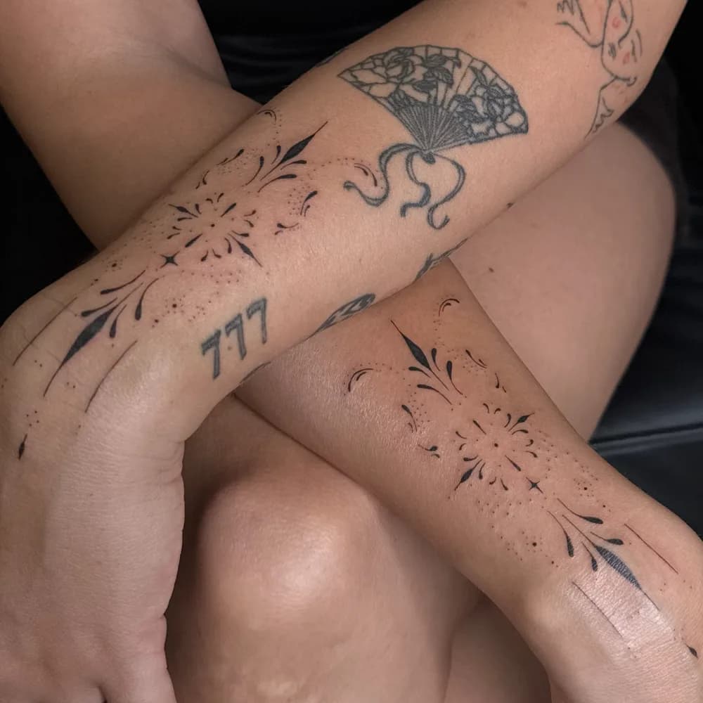 Gros plan des tatouages ornementaux assortis sur les deux poignets